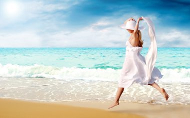 Young beautiful women in the white on the sunny tropical beach clipart