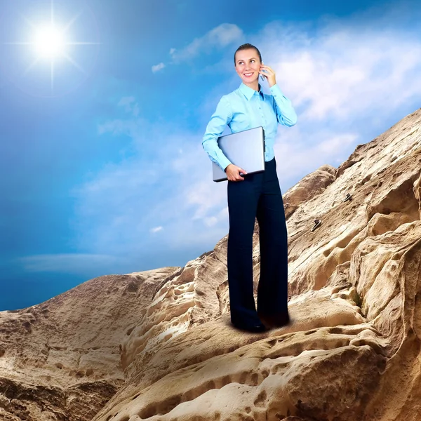 Щаслива бізнес-леді стоїть з ноутбуком на горі під б — стокове фото