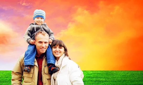 Glad familj porträtt utomhus leende med en blå himmel — Stockfoto