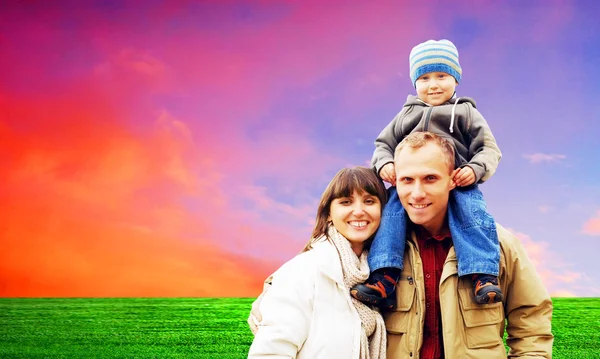 Açık mavi gökyüzü ile gülümseyerek mutlu bir aile portresi — Stok fotoğraf