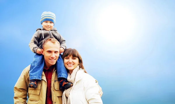 Gelukkig familie portret buitenshuis lachend met een blauwe hemel — Stockfoto