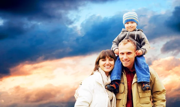 Ευτυχισμένη οικογένεια πορτρέτο χαμογελώντας σε εξωτερικούς χώρους με έναν μπλε ουρανό — Φωτογραφία Αρχείου