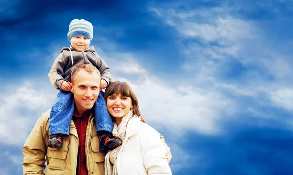 Feliz retrato familiar al aire libre sonriendo con un cielo azul —  Fotos de Stock