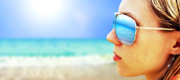 Chica joven en gafas está buscando en la playa de sol tropical —  Fotos de Stock