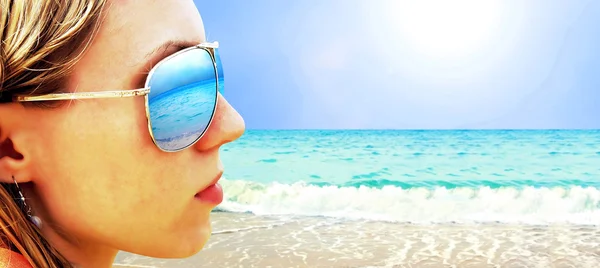 Młoda dziewczyna w okularach jest patrząc na plaży słońce tropikalny — Zdjęcie stockowe