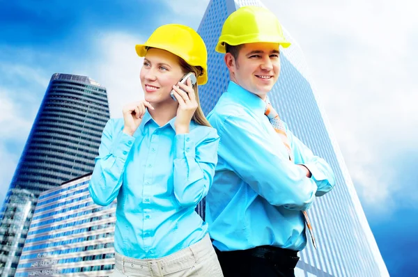 Jovens arquitetos vestindo um capacete de proteção em pé no bui — Fotografia de Stock