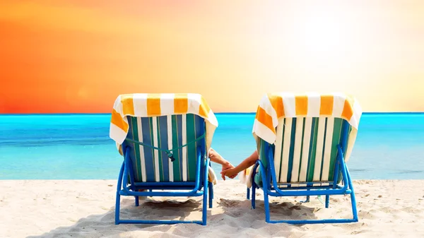 Zadní pohled na pár na relaxační lehátko na pláži — Stock fotografie