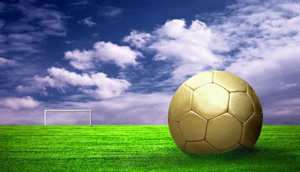 Yeşil çim ve gökyüzü arka plan üzerinde futbol topu — Stok fotoğraf