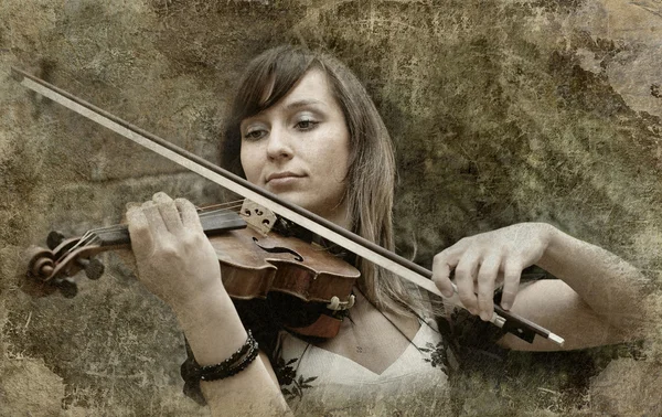 Gyönyörű női hegedűművész játszik hegedű a grunge háttérb — Stock Fotó