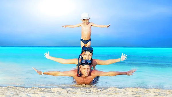 Šťastný mladý pár a syn s šnorchlování na mořskou pláž — Stock fotografie