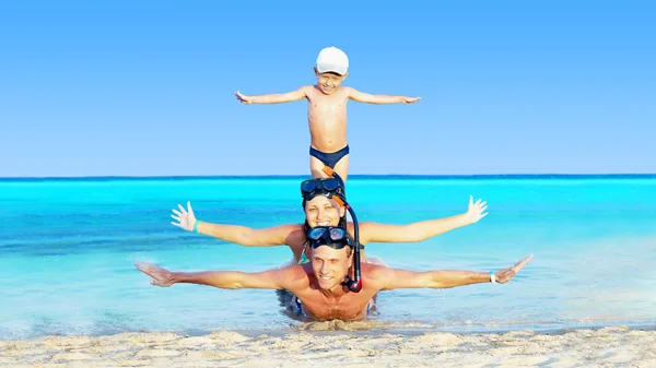 Happy νεαρό ζευγάρι και ο γιος με κολύμβηση με αναπνευστήρα σε μια παραλία στη θάλασσα — Φωτογραφία Αρχείου