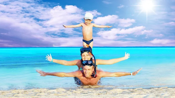Felice giovane coppia e figlio con snorkeling su una spiaggia di mare — Foto Stock