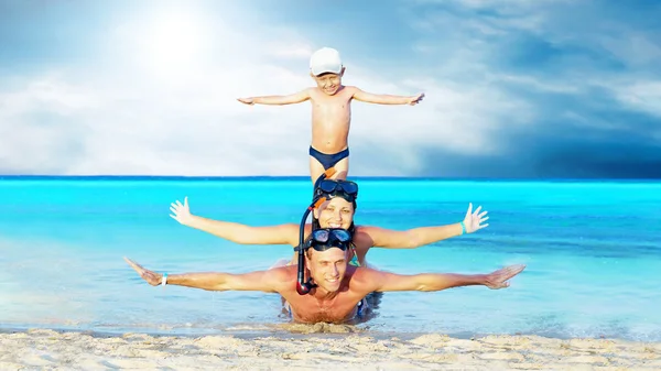 Jovem casal feliz e filho com snorkelling em uma praia do mar — Fotografia de Stock