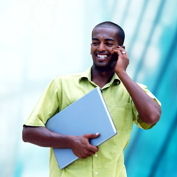 Young happy black man or student with laptop on the business bac — Stock Photo, Image