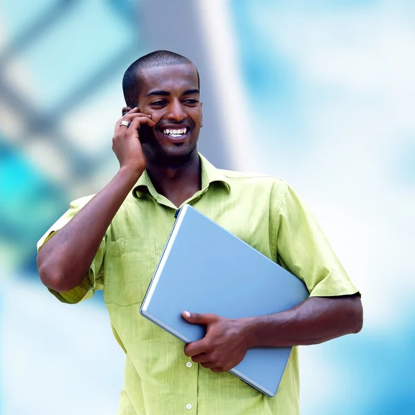 Young happy black man or student with laptop on the business bac — Stock Photo, Image