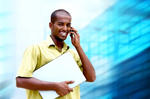 Junger glücklicher Mann oder Student mit Laptop und Telefon im Geschäft — Stockfoto