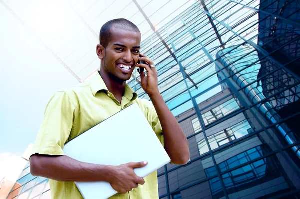 Junger glücklicher Mann oder Student mit Laptop und Telefon im Geschäft — Stockfoto