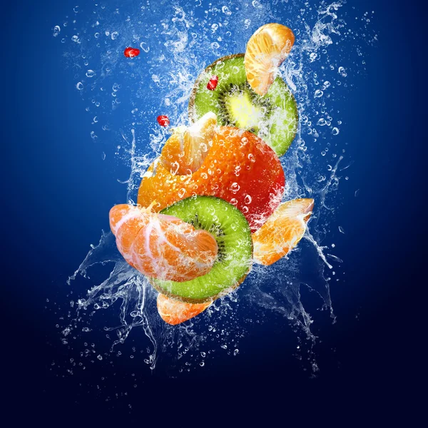 Gotas de agua alrededor de frutas sobre fondo azul — Foto de Stock