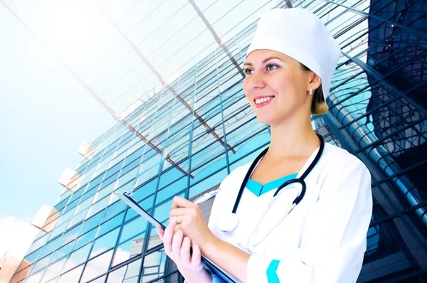 Smiling medical doctor with stethoscope on the hospitals backgro — Stock Photo, Image