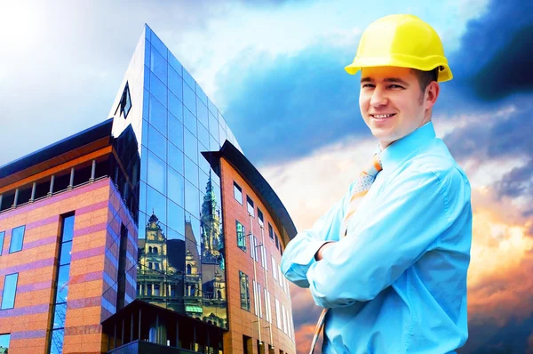 Молодий архітектор у захисному шоломі стоїть на бульйоні — стокове фото