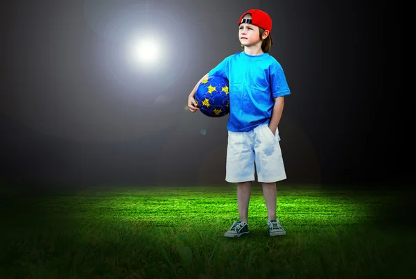 Счастье маленького мальчика на поле стадиона со светом — стоковое фото