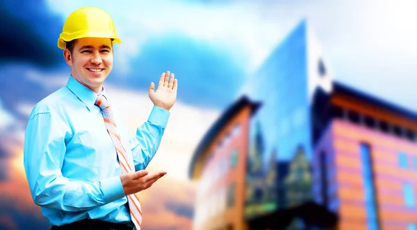 Молодой архитектор в защитном шлеме стоит на буиле — стоковое фото