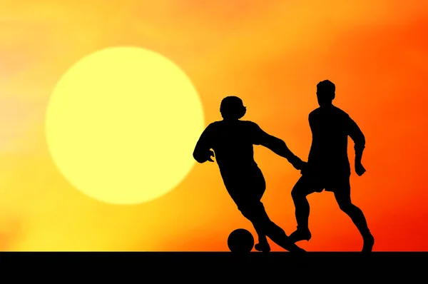 Silhouetten von Fußballern am Himmel des Sonnenuntergangs — Stockfoto
