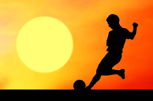 Siluety fotbalisty na západu slunce obloha — Stock fotografie