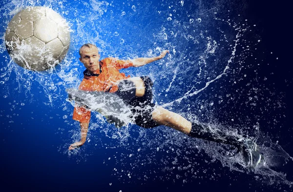 Вода падає навколо футболіста під водою на синьому фоні — стокове фото