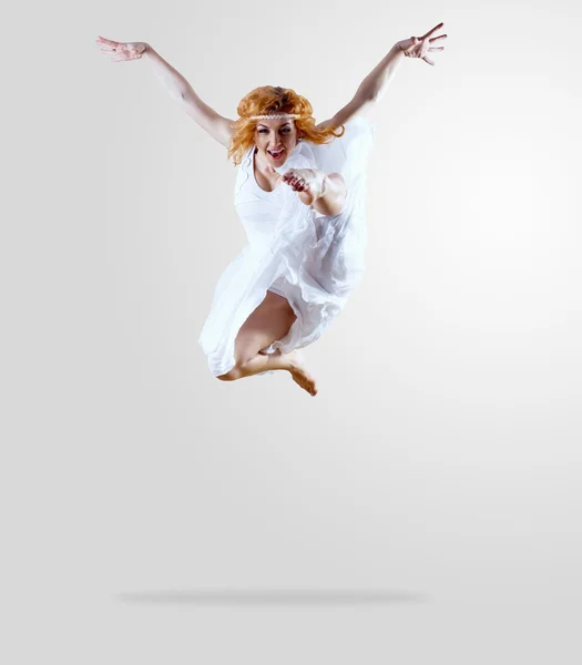 Nő táncos ugrás pózol a háttérben — Stock Fotó