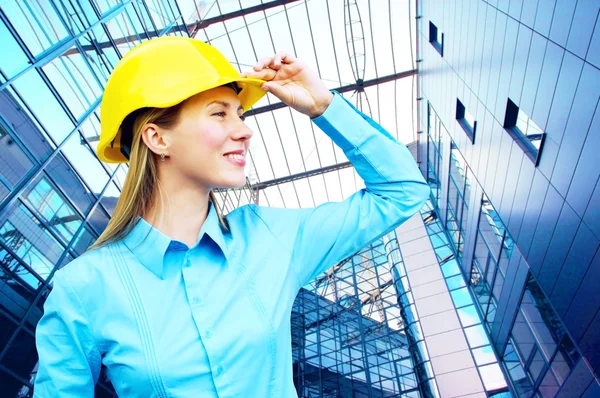 年轻的建筑师女人穿防护头盔常设的 th — 图库照片