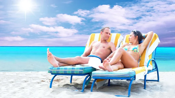 Vista trasera de una pareja en una tumbona relajante en la playa — Foto de Stock