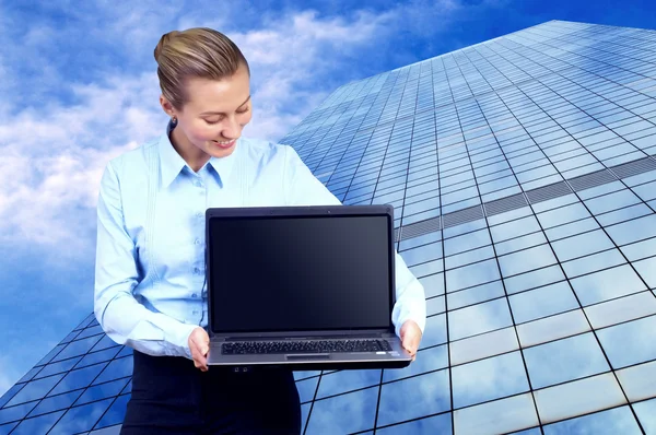 Geluk zakenvrouw met laptop op vervagen zakelijke architectur — Stockfoto