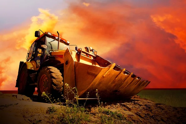 Altın surise gökyüzü üzerinde sarı traktör — Stok fotoğraf