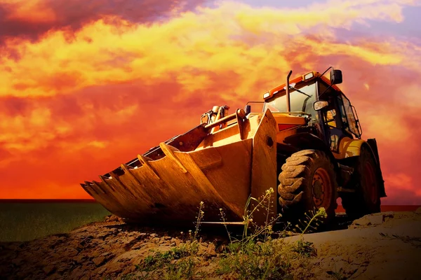 Gelber Traktor am goldenen Himmel — Stockfoto