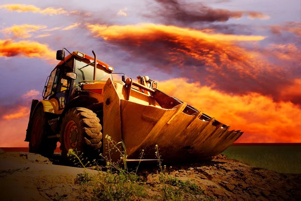 Žlutá traktor na Zlatý surise sky — Stock fotografie