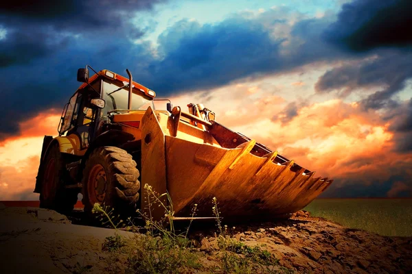 Yellow tractor on golden surise sky — Stock Photo, Image