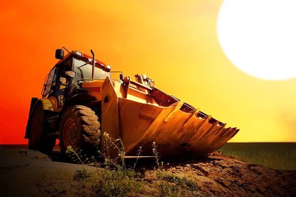 Žlutá traktor na Zlatý surise sky — Stock fotografie