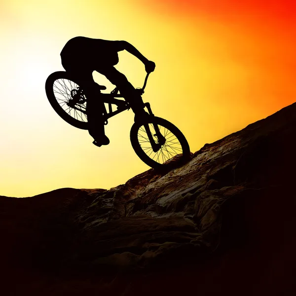 Silueta muže na muontain-na kole, při západu slunce — Stock fotografie
