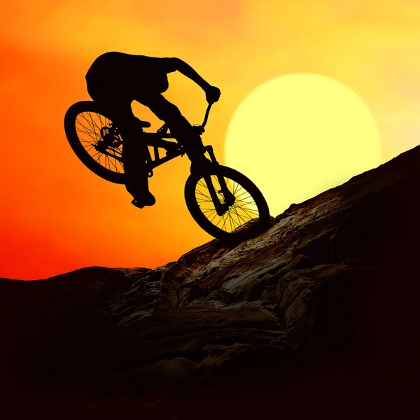 Silhouet van een man op muontain-bike, zonsondergang — Stockfoto