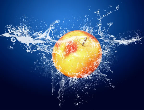Вода падає навколо яблука на синьому фоні — стокове фото