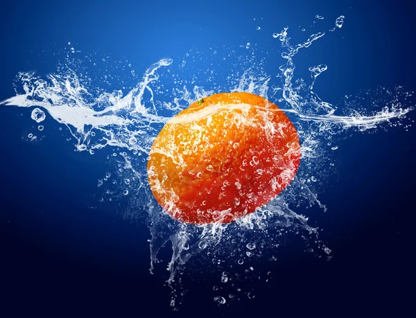 Вода падає навколо мандарина на синьому фоні — стокове фото