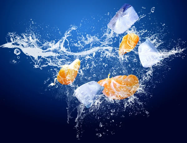 Wassertropfen um Mandarine und Eis auf blauem Hintergrund — Stockfoto