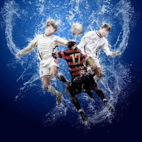 Вода падає навколо футболістів під водою на синьому фоні — стокове фото