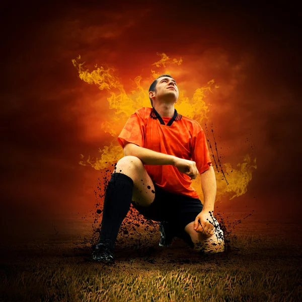 Football player in fires flame on the outdoors field — Stockfoto