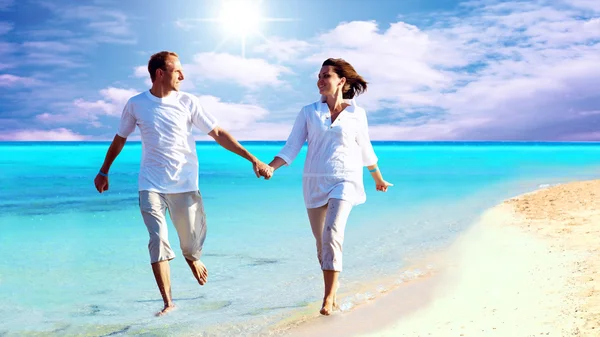 Vista de feliz jovem casal andando na praia, de mãos dadas . — Fotografia de Stock