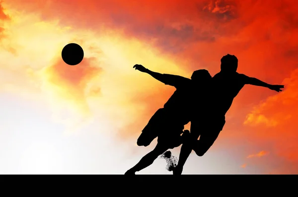 stock image Silhouettes of footballers on the sunset sky