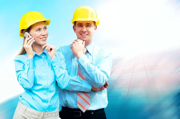 Jóvenes arquitectos con un casco protector de pie en el bui — Foto de Stock