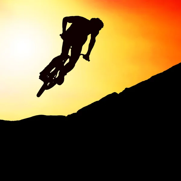 La silueta de un hombre en moto de montaña, puesta de sol —  Fotos de Stock