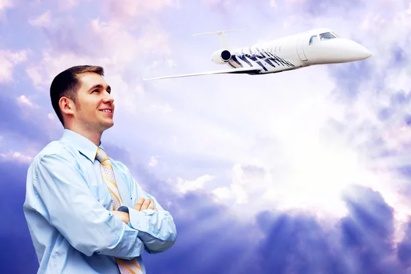 Šťastný podnikatel na modrou oblohu s letadlem — Stock fotografie